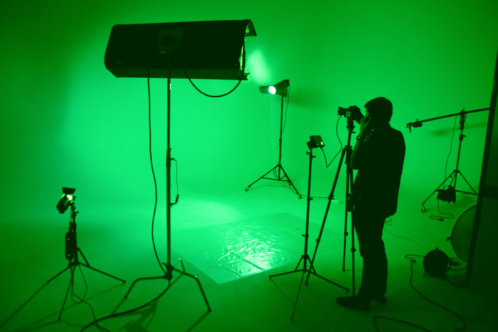 filmmaker in a green set